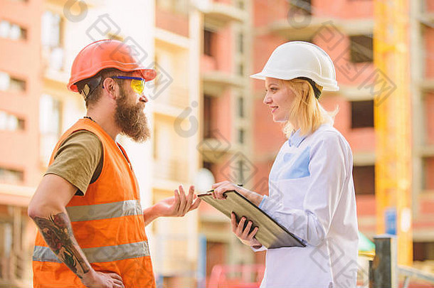 建设<strong>工程监理</strong>。安全检查员概念。女检查员和留胡子的野蛮建筑工人讨论施工进度。施工现场安全检查。讨论项目进展。