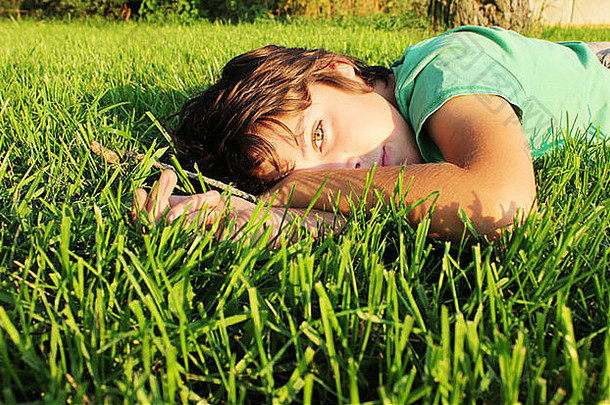 少年男孩放松绿色草草坪上