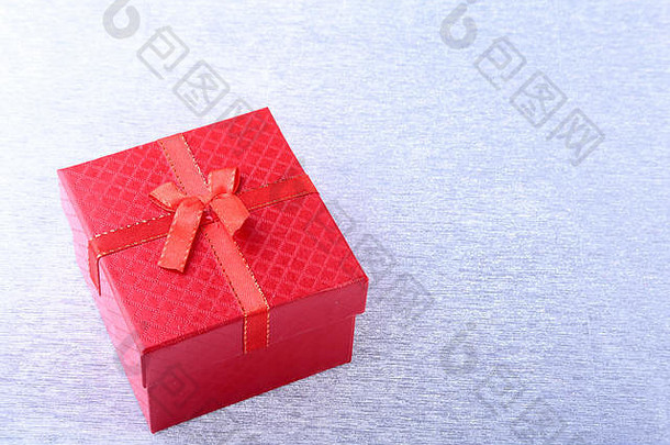 木制背景上带有蝴蝶结的礼品盒。圣诞装饰。