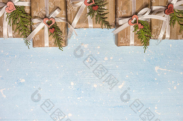 圣诞礼物用工艺纸包裹，背景为浅蓝色纹理。明信片或<strong>邀请函</strong>的节日和庆祝概念。俯视与<strong>公司</strong>
