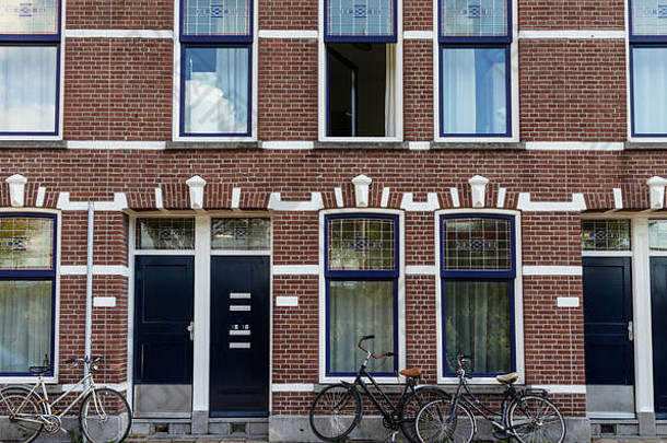 鹿特丹，荷兰。自行车在传统的红砖房子前面，背景是蓝色的窗户。