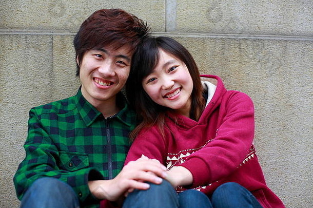 快乐的年轻亚洲女孩和她的男朋友在户外一起