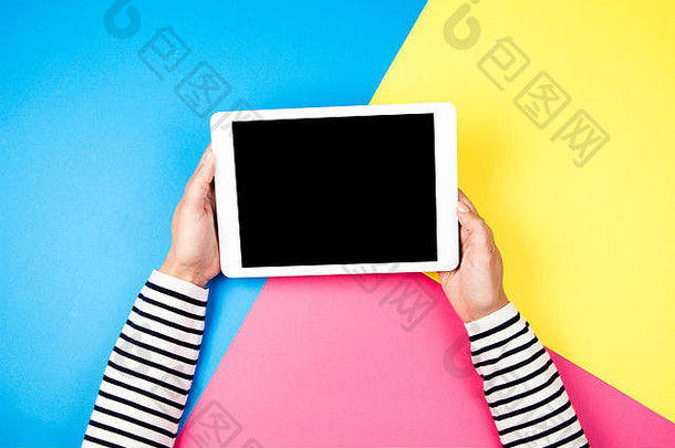 女人的手平板电脑电脑色彩斑斓的背景