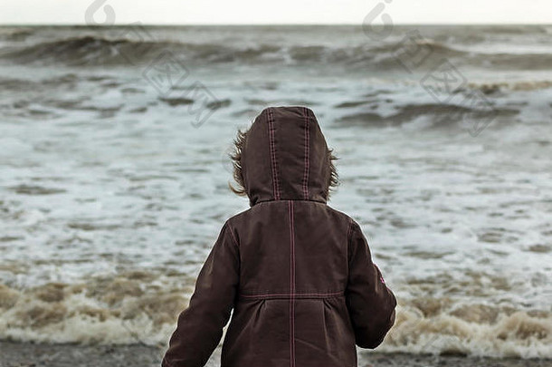 灰蒙蒙的日子里，一个小孩望着大海