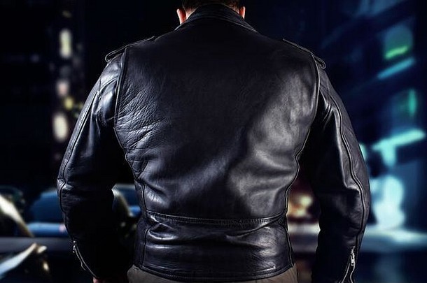 特写镜头照片男人。黑色的皮革骑摩托车的人夹克站黑色的背景