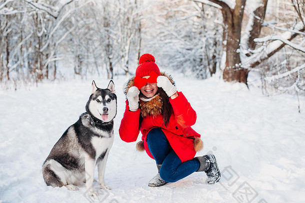 小女孩和她的哈士奇狗在冬季公园。家养宠物。<strong>深沉</strong>沙哑的