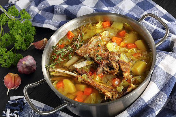 美味的冰岛羊肉冬天热汤蔬菜香料克约苏帕不锈钢钢砂锅锅木表格厨房毛巾