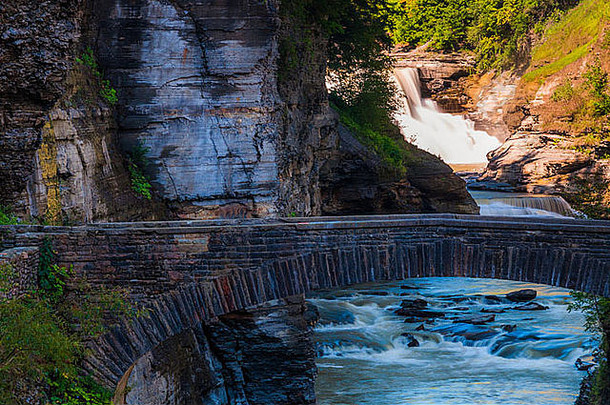 纽约州莱奇沃斯州立公园，下瀑布和一座步行桥横跨吉纳西河峡谷。