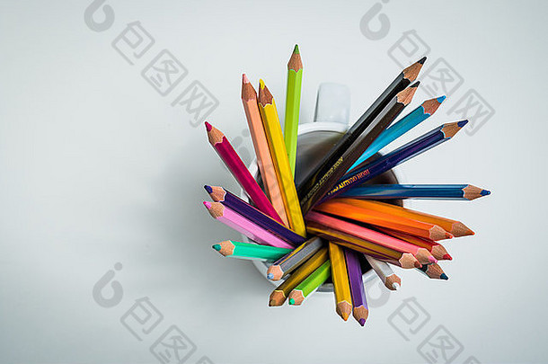 一组彩色铅笔，在白色孤立背景中，从高角度放在杯子里