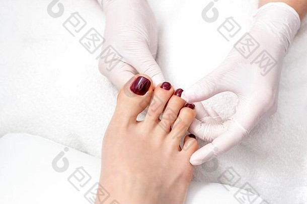 前视图人类手保护手套持有女人脚画脚趾甲黑暗红色的颜色奥蒂沙龙