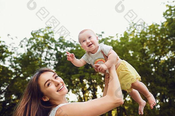 一位快乐的母亲正在公园里和一个蹒跚学步的孩子玩耍。