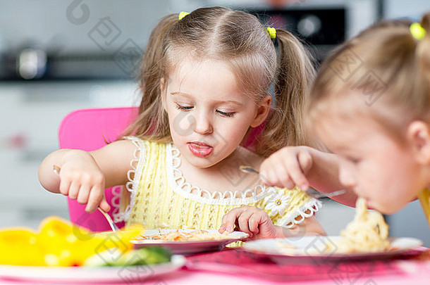 孩子们在托儿所吃意大利面条和蔬菜