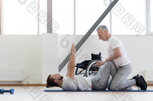 积极的物理治疗师在健身房帮助残疾人