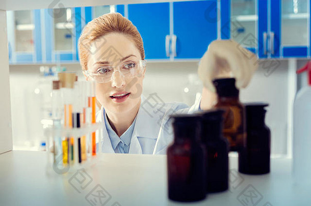 美丽的女科学家采取瓶化学液体