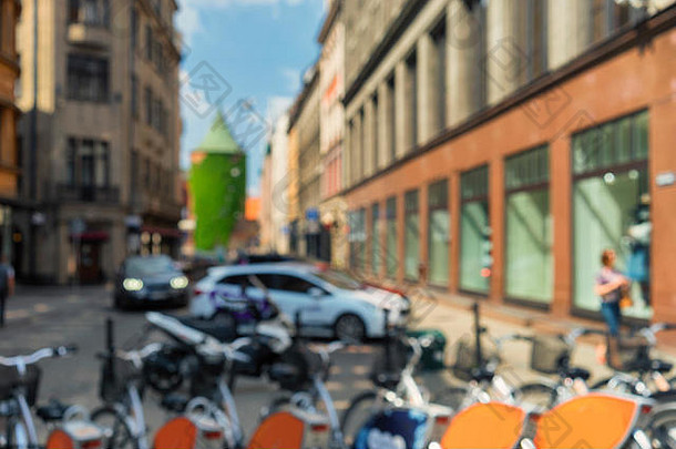 在阳光明媚的夏天，里加古城中心的街头生活充斥着汽车和自行车。模糊的