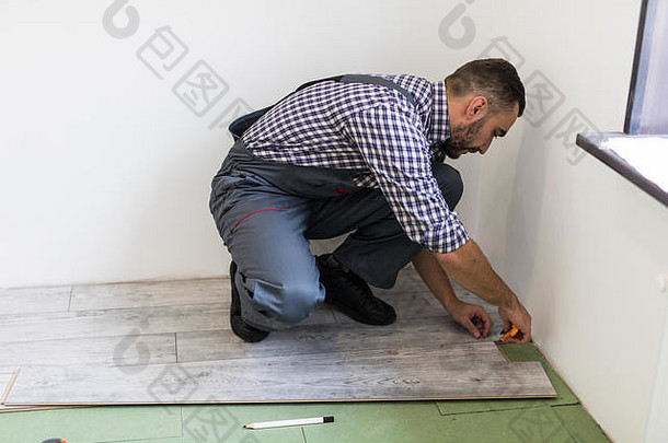 男人。工人安装木层压板地板