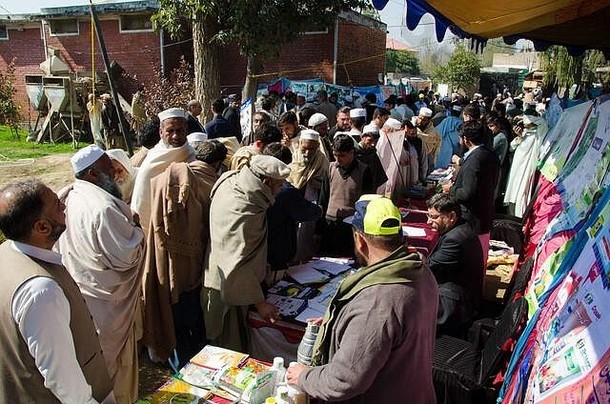 巴基斯坦Mardan KPK的农民参加了一个演示活动，聆听农业公司的预设并参观信息摊位。
