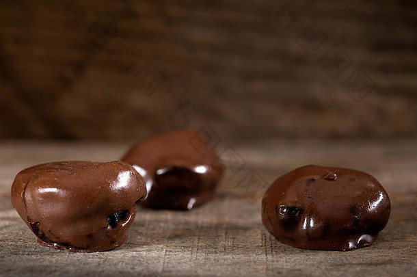 质朴木质背景上的巧克力李子