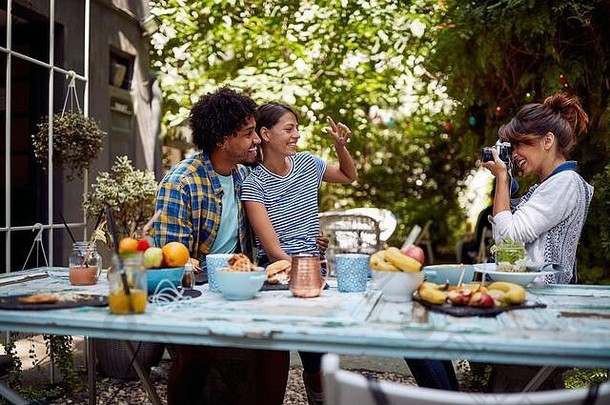 女孩采取照片年轻的可爱的夫妇咖啡馆的花园