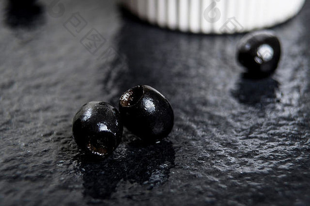 湿黑石桌上的黑橄榄