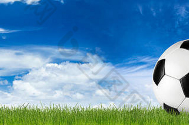 复古的黑色的白色皮革足球球草前面蓝色的天空