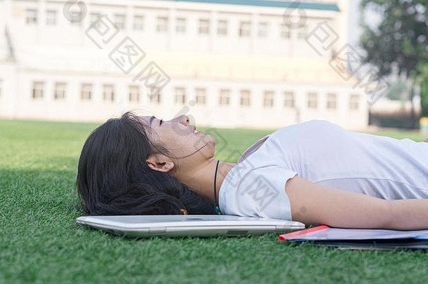 女大学学生谎言操场上草坪上休息