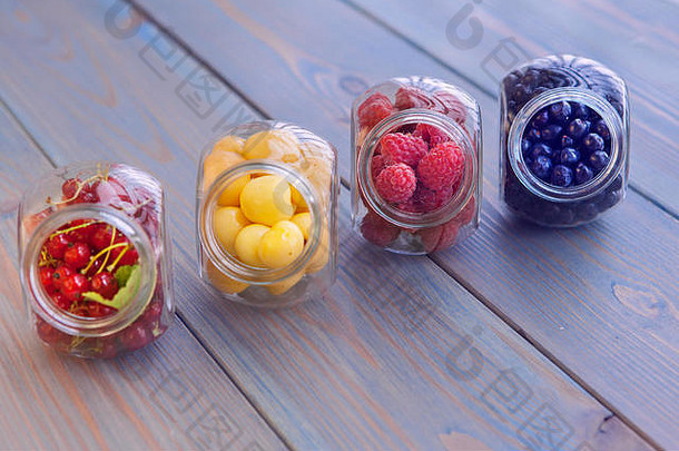 木质背景玻璃罐中的健康有机浆果。樱桃、浆果、蓝莓、覆盆<strong>子</strong>