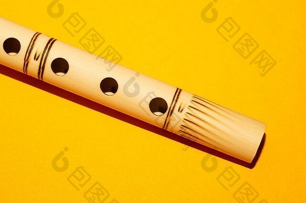 竹笛。简单的管乐器。黄色背景班苏里长笛