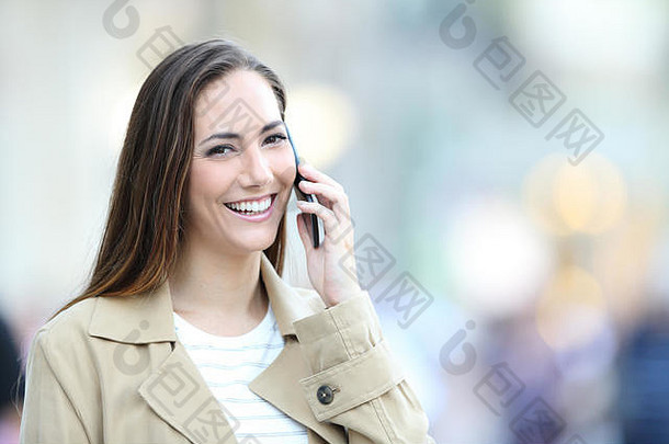 快乐女人用智能手机聊天，看着街上的摄像机