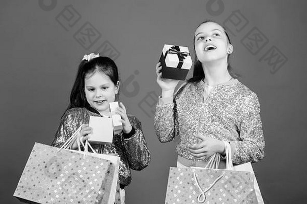 购物和购买。黑色星期五。销售和折扣。购物日。孩子们把包裹捆起来。儿童时尚。带蓝色背景购物袋的女孩姐妹朋友。交付给您的所有产品。