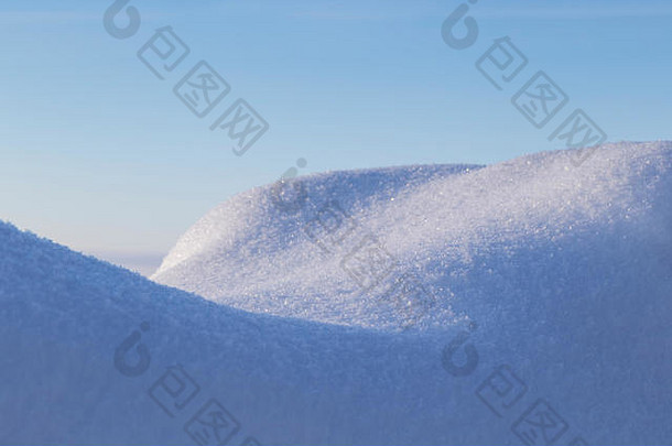 <strong>冬季</strong>阳光明媚的日子里，雪堆<strong>上新</strong>鲜闪亮的雪的特写镜头。晴朗的蓝天。