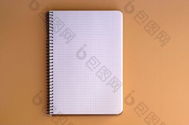 带有弹簧和床单的笔记本电脑，位于笼状俯视图中。米黄色背景的笔记本中的空白纸。文具，笔记本，笔记。空间。
