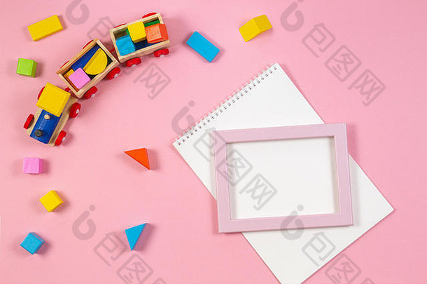 木玩具火车色彩斑斓的多维数据集白色开放笔记本胜利阵线框架粉红色的背景