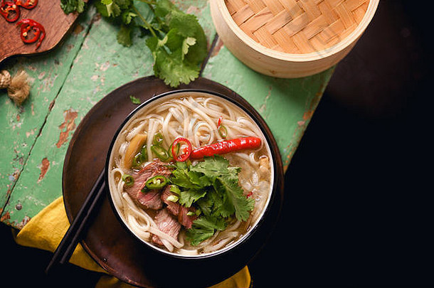 越南传统的汤巨像牛肉新鲜的香菜乡村木表格
