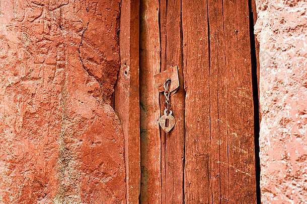 橙色漆木门上的复古金属门链把手