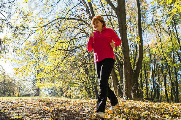 女子在秋季公园跑步