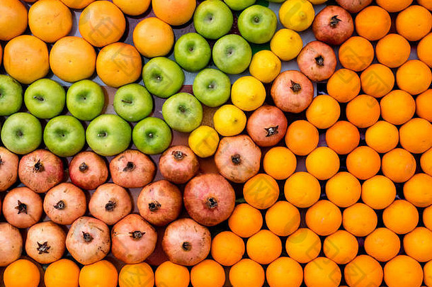农贸市场上的青苹果、石榴、橙子和柠檬的水果背景。