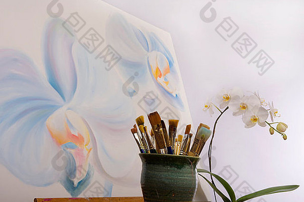 在艺术家的画室里，一幅蝴蝶兰的画，前景是她的画笔
