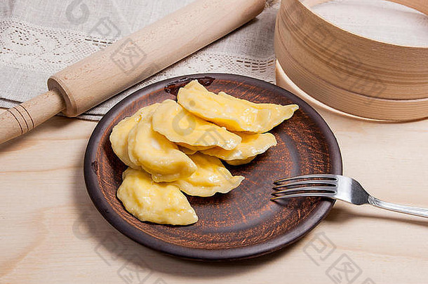 新鲜的煮熟的自制的乌克兰饺子小屋奶酪凝乳黄油粘土板金属叉木背景瓦伦尼基dumpli