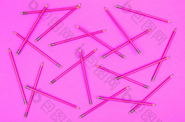 粉红色霓虹灯背景上的铅笔。回到学校的概念。水平的