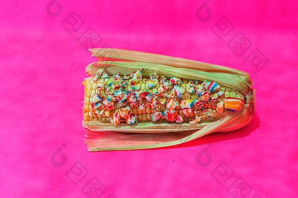 粉红色背景上的玉米和糖果