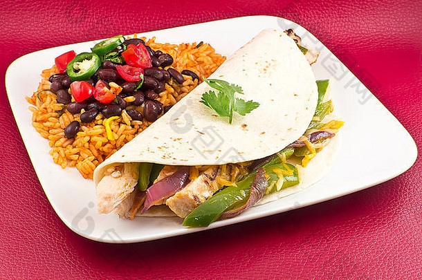 墨西哥<strong>鸡肉</strong>法吉塔（fajita），配青椒片、红洋葱和面粉玉米粉圆饼，配黑豆和米饭