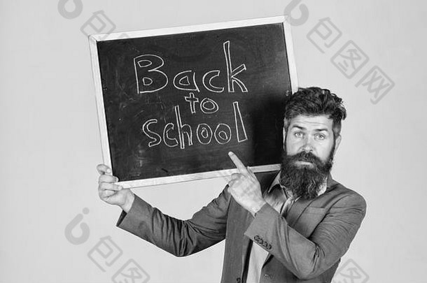 老师回学校做<strong>广告</strong>，开始新学年。留着胡子的老师站起来，拿着写有铭文的黑板回到学校灰色的背景。邀请来庆祝知识日。