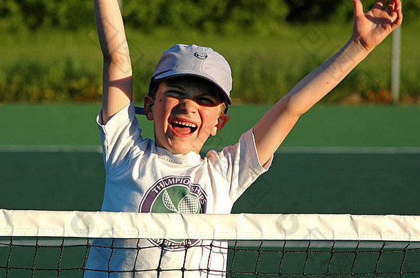冠军，一个赢得网球比赛后欢呼的年轻男孩的肖像，看起来很得意洋洋