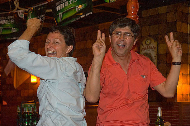 两个50/60岁的年轻人在度假时在酒吧里聚会跳舞到深夜——永远年轻。