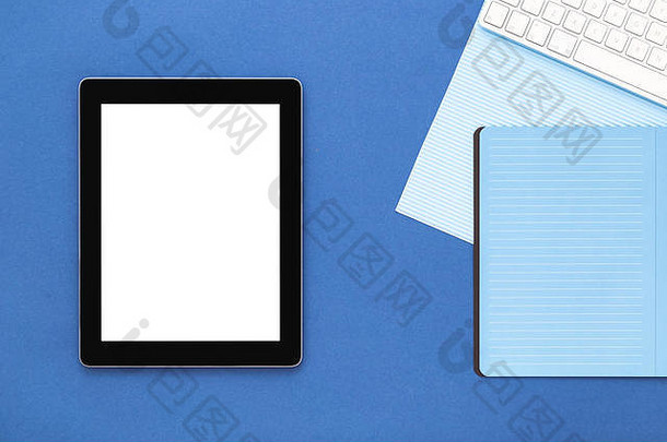 蓝色创意桌面视图。简约设计。平板电脑、键盘和笔记本电脑。