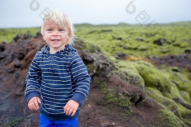 微笑蹒跚学步的孩子男孩摆姿势前面美丽的羊毛的莫斯多雨的一天冰岛秋季