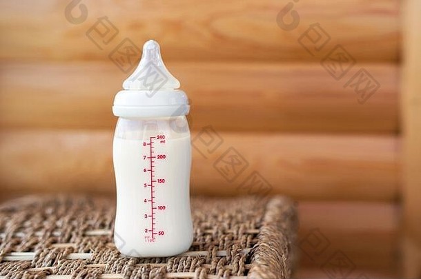 木制背景上的婴儿奶瓶。妇幼保健概念。顶视图。免费拷贝空间。