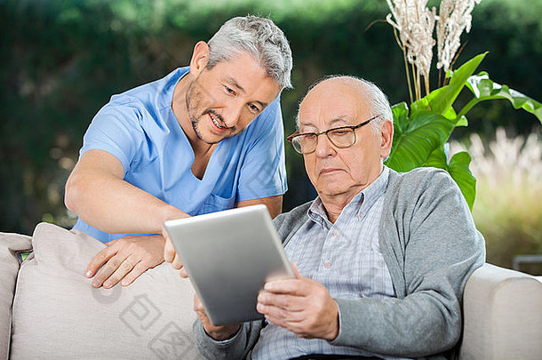 管理员协助老人使用数字平板电脑