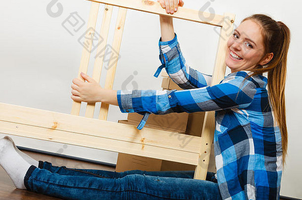 木制家具的女人。DIY爱好者。年轻女孩正在做家庭装修。